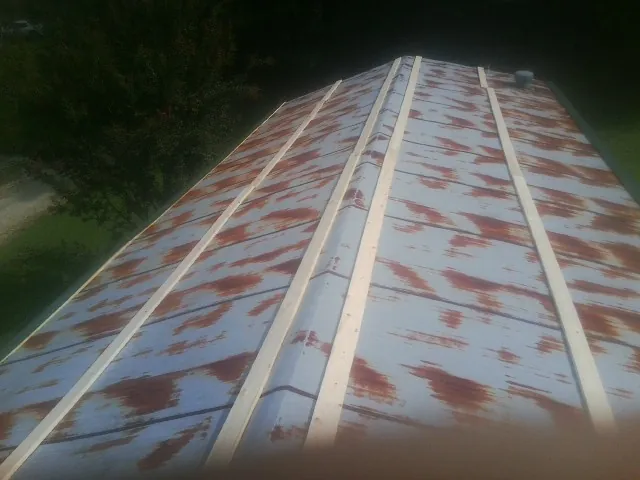 Rusted metal roof panels with new wood purlins before replacement — Storm Damage Roof Repair in Vaughn by Roofing Brothers