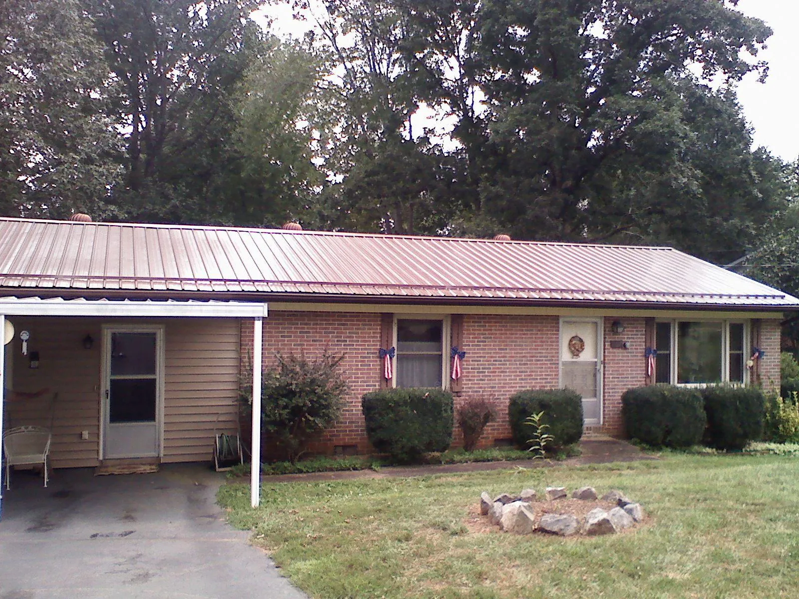 Bronze metal roof and carport on a brick ranch home — Roof Repair work by our crew in Vaughn